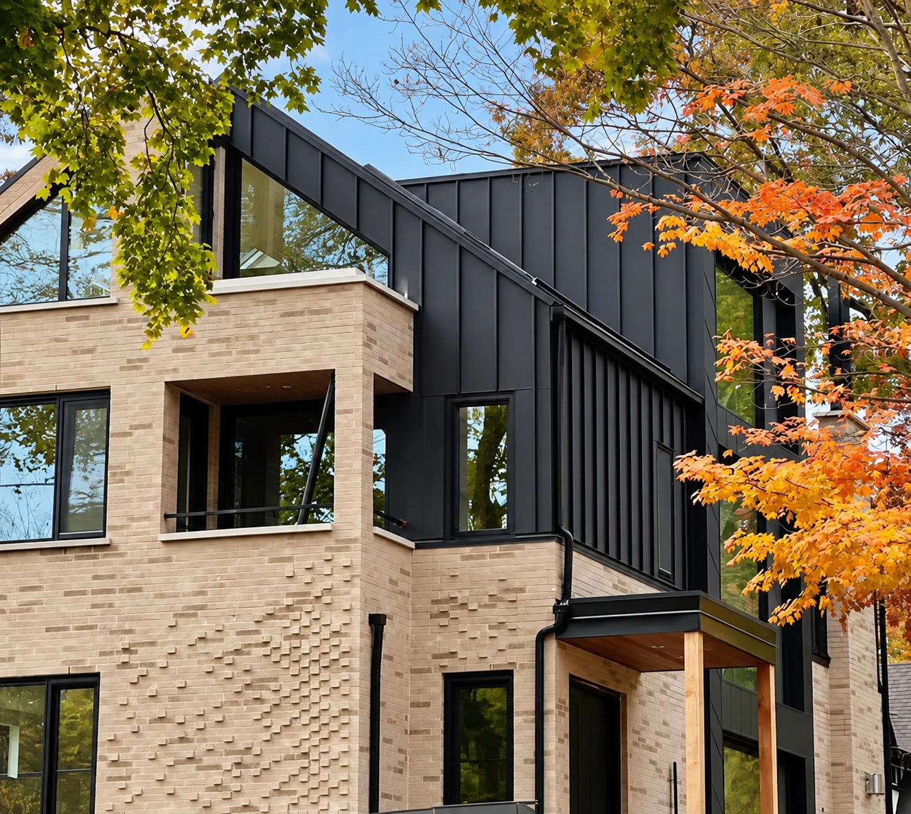 Exterior detail with black metal cladding, pale masonry and autumn trees
